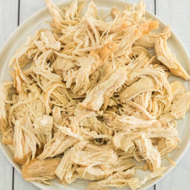 Shredding chicken on plate.