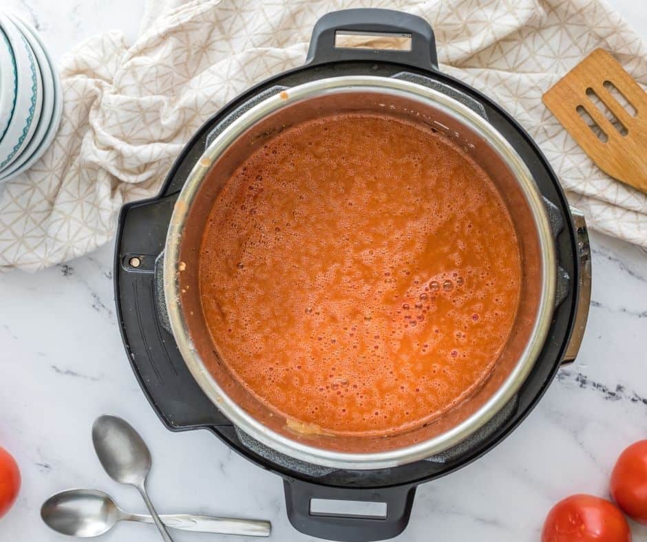"Stirring in tomato paste and seasonings into the Instant Pot for the tomato soup base."