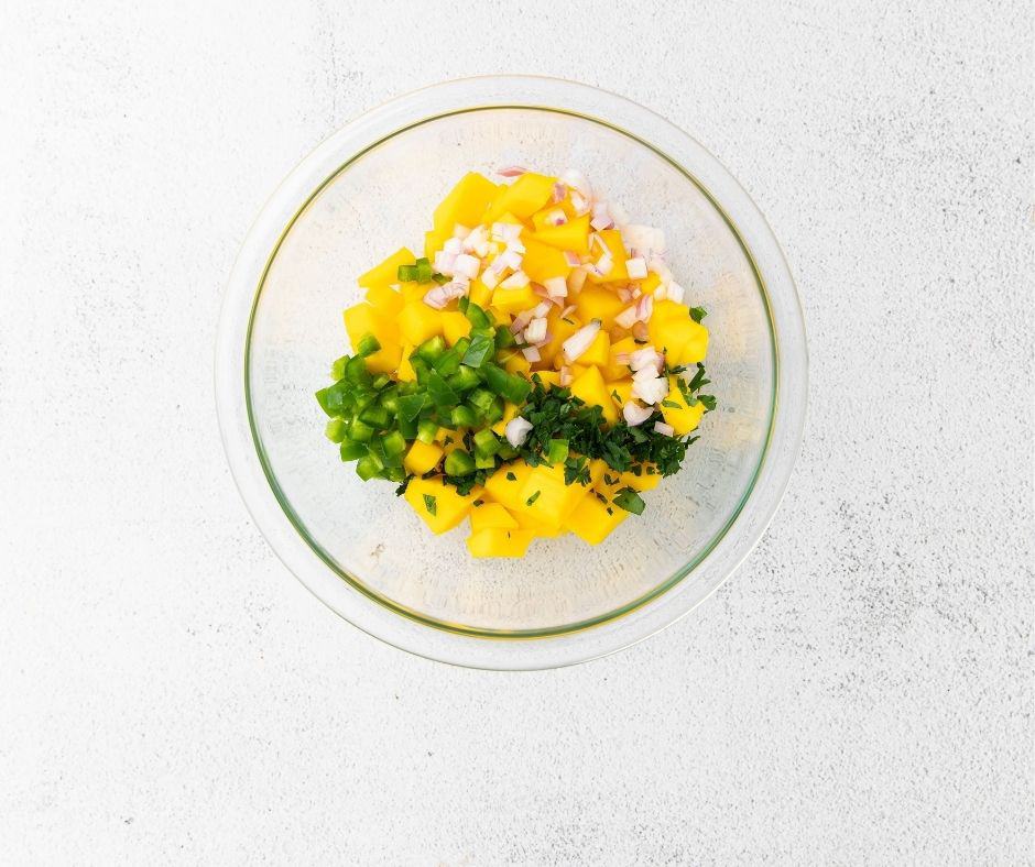 All all of the mango salsa ingredients to a large bowl