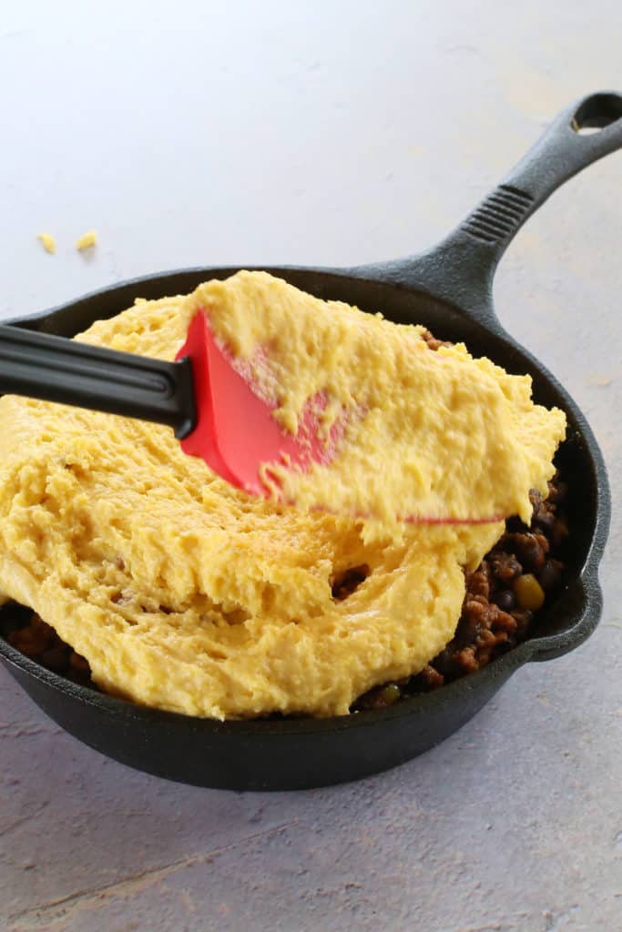 In a small bowl, combine corn muffin mix, egg and milk. Stir until smooth. Top chili with batter. Bake in a preheated 375°F air fryer for 18-20  minutes or until golden.
