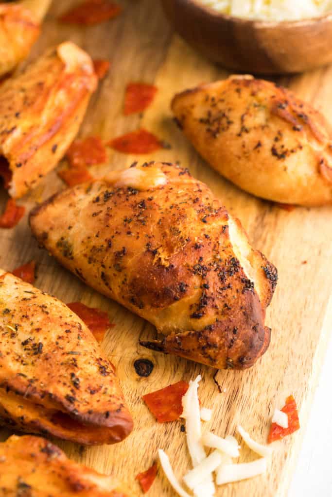 Golden brown Air Fryer Pizza Pockets with melted cheese oozing out.