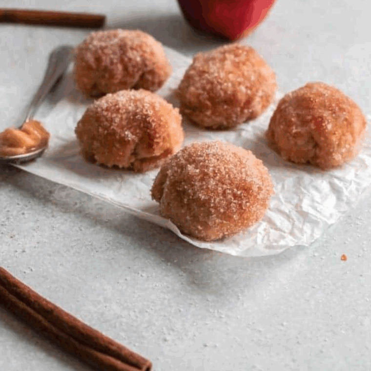 Cinnamon sugar stuffed apple donuts cut open to show apple filling