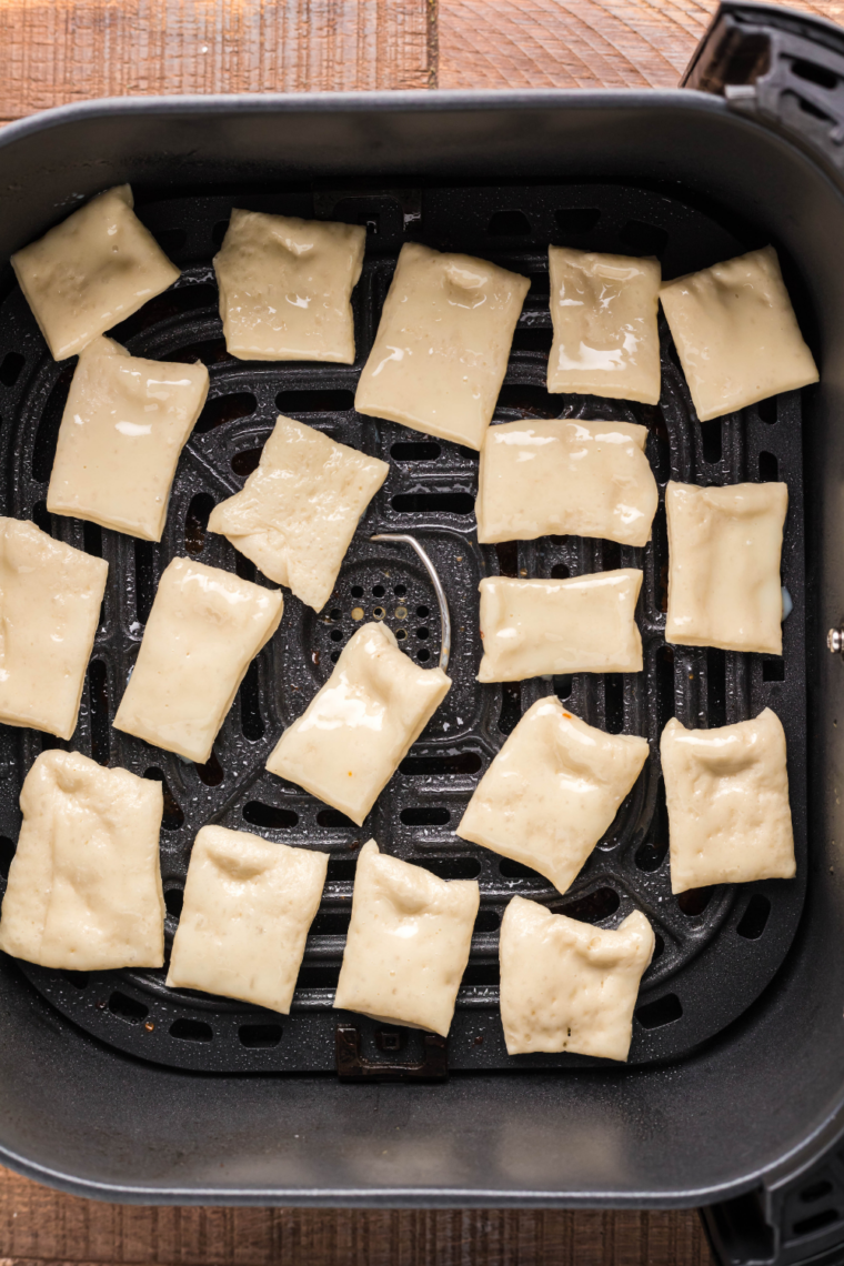 Puff pastry squares arranged in air fryer basket cooking until golden, puffed, and crispy at 400°F
