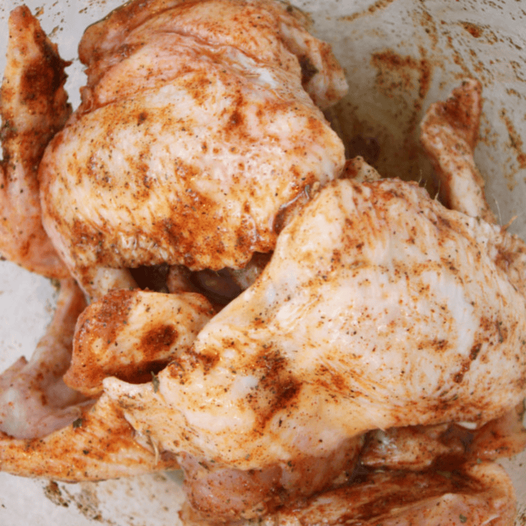 Placing dry rubbed chicken wings in the air fryer basket