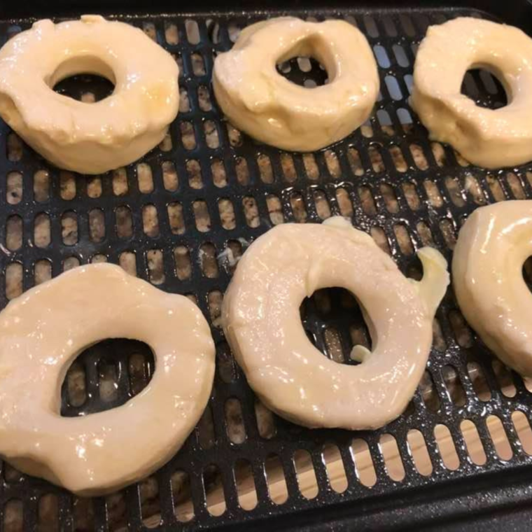 After dipping in butter, place your donuts in your air fryer basket or air fryer oven tray.