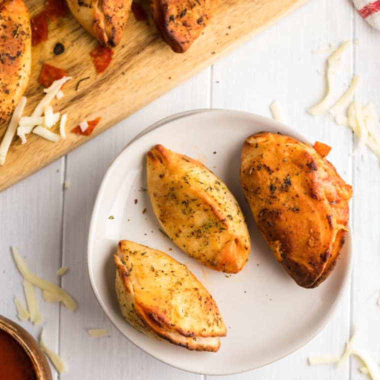 Golden brown air fryer pizza pockets with melted cheese oozing out.