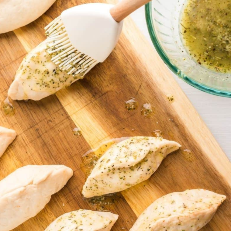 Finishing the pizza pockets with a garlic butter and herb topping.