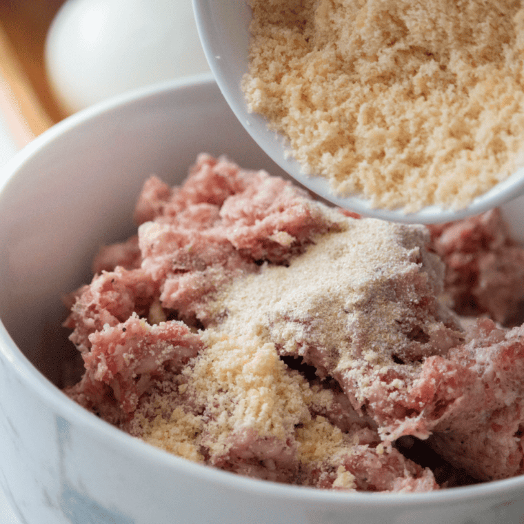Flattened portions of sausage meat seasoned with herbs and spices, ready for wrapping eggs