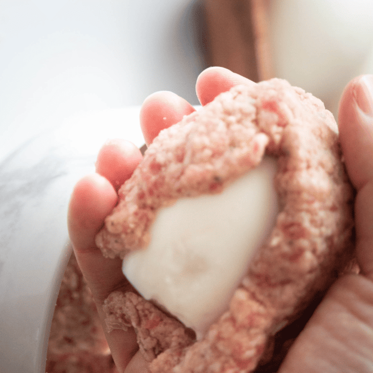 Hard-boiled eggs fully wrapped in a layer of seasoned sausage meat