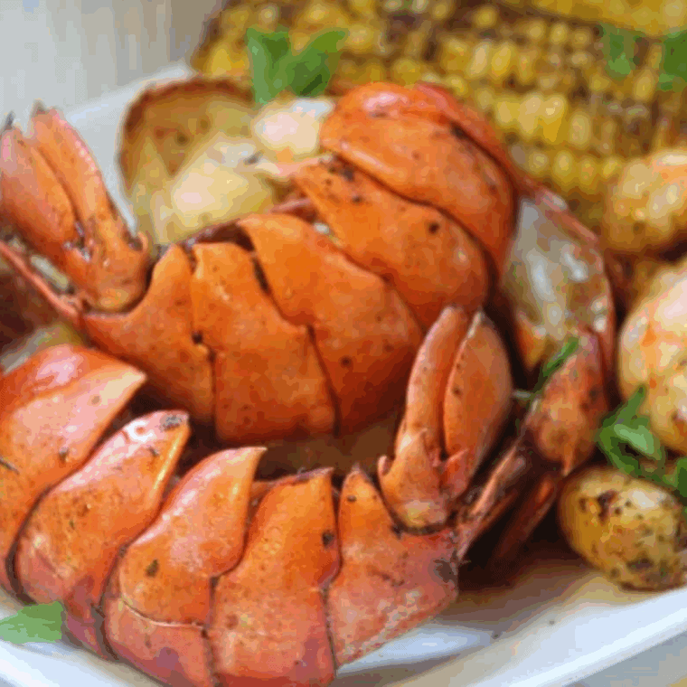 Delicious Air Fryer Seafood Boil with lobster, shrimp, corn, and seasoning, served on a platter.