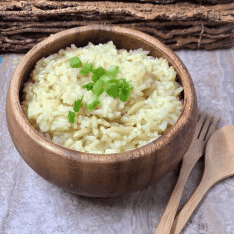 A bowl of Applebee’s Almond Rice Pilaf garnished with toasted sliced almonds and fresh herbs.