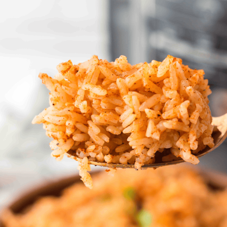 Instant Pot Spanish rice fluffy and golden red served in white bowl with cilantro garnish