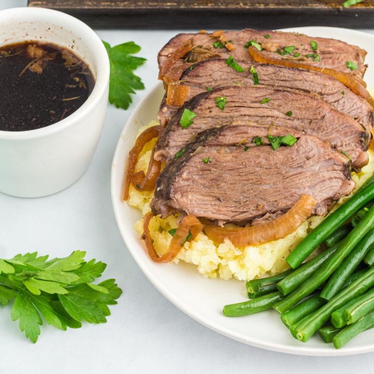 Close up of Juicy Air Fryer Tri Tip Steak on plate with mashed potatoes and juices.