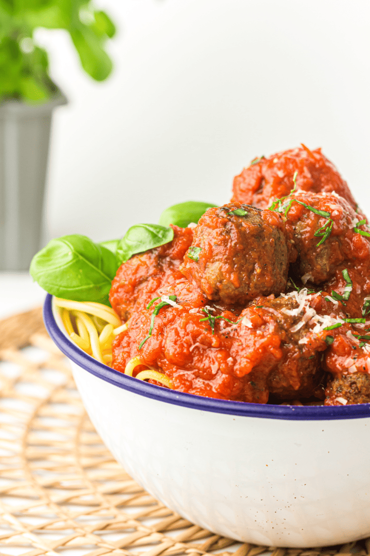 Olive Garden Meatballs in a bowl served with marinara sauce and garnished with fresh parsley.