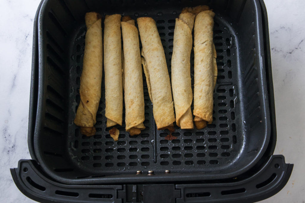 Preheat the Air Fryer:
Preheat your air fryer to 400 degrees F (190°C) for 1-2 minutes. Preheating ensures even cooking and a crispy texture.
Lightly Coat with Cooking Spray (Optional):
While this step is optional, lightly spraying the taquitos with cooking spray can help them become even crispier. You can skip this step if you prefer.
Arrange in the Air Fryer:
Place taquitos in a single layer in the air fryer basket or on the air fryer tray. Avoid overcrowding to allow proper air circulation. If your air fryer is small, you may need to cook them in batches.
Air Fry the Taquitos:
Set the cooking temperature to 400 degrees Fahrenheit, and the cooking time for 8-10 minutes, shaking the basket or flipping them halfway through the cooking process to ensure even browning.
Optional Toppings:
If you'd like to add shredded cheese, sprinkle it on the taquitos during the last 2 minutes of cooking. This allows the cheese to melt and become gooey.
Check for Crispy Perfection:
The taquitos are done when they are golden brown and crispy. Keep an eye on them during the last few minutes to avoid overcooking.
Serving
Remove the taquitos from the air fryer and let them cool for a minute or two. They are best enjoyed while still hot and crispy. Garnish the taquitos with fresh cilantro, lime wedges, avocado, jalapeño, or other toppings of your choice for added flavor and presentation. Season the taquitos with a pinch of salt and freshly ground black pepper to taste! Serve your hot and crispy air fryer frozen taquitos with your favorite dipping sauces or toppings for a delicious and convenient snack or meal.