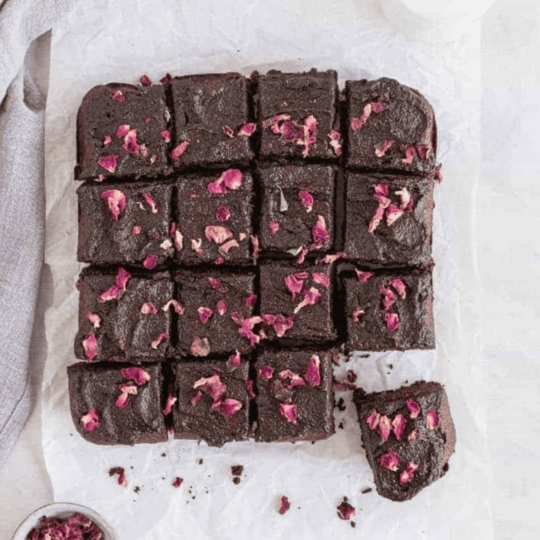 Air Fryer Zucchini Brownies on a plate, showing a dense, fudgy texture with a rich chocolate color, garnished with a sprinkle of powdered sugar and a few zucchini slices for decoration