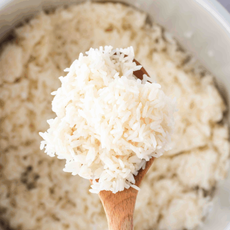 Adding rice and liquid: Stirring rinsed rice, broth, lemon juice, and seasonings in the Instant Pot