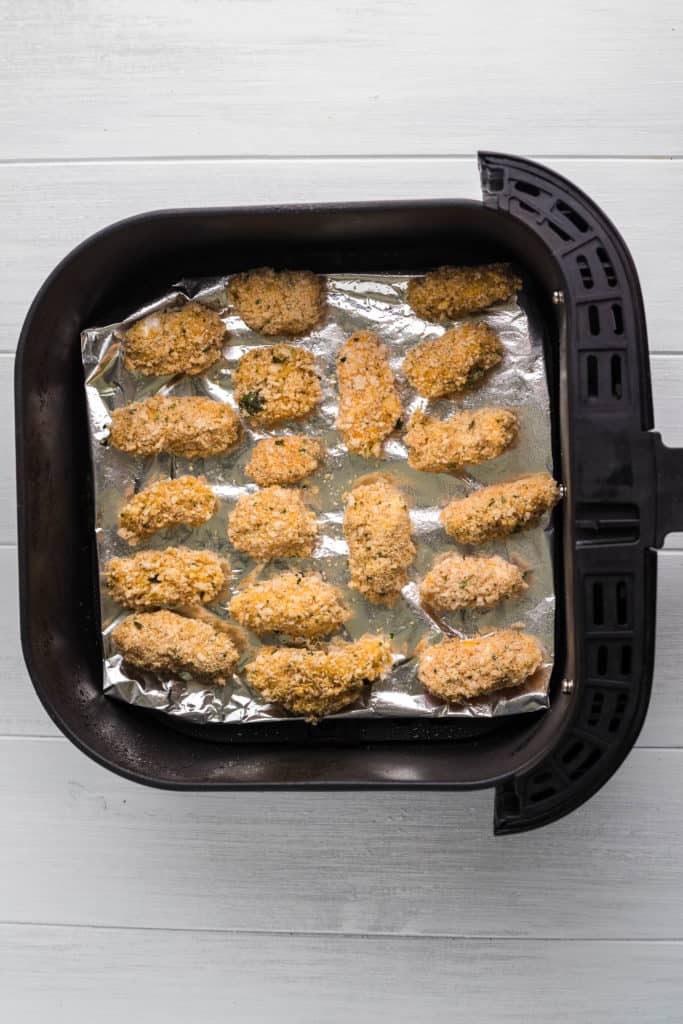 Cooking Air Fryer Frozen Cheese Curds in the air fryer basket, in a single layer.