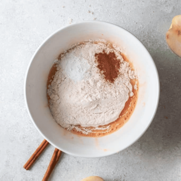 Flour, sugar, cinnamon, eggs and diced apples measured out for fritters