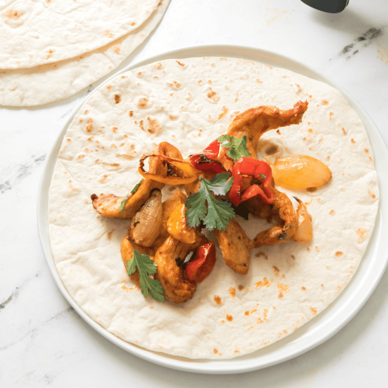 Charred chicken fajita strips and peppers served with tortillas and toppings