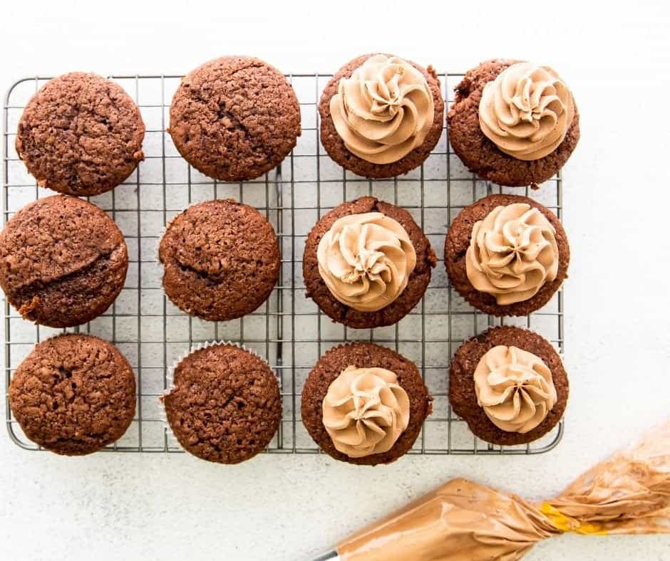 Cupcakes being decorated with frosting.