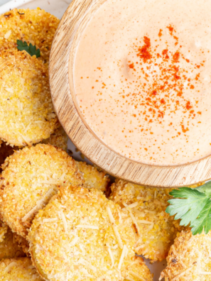 Crispy air fryer fried squash rounds with golden cornmeal breading stacked on a white plate