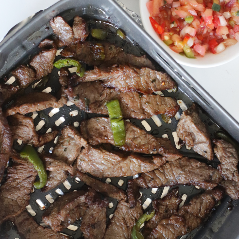 Sliced bell peppers and onion tossed with oil and cumin for air fryer fajitas