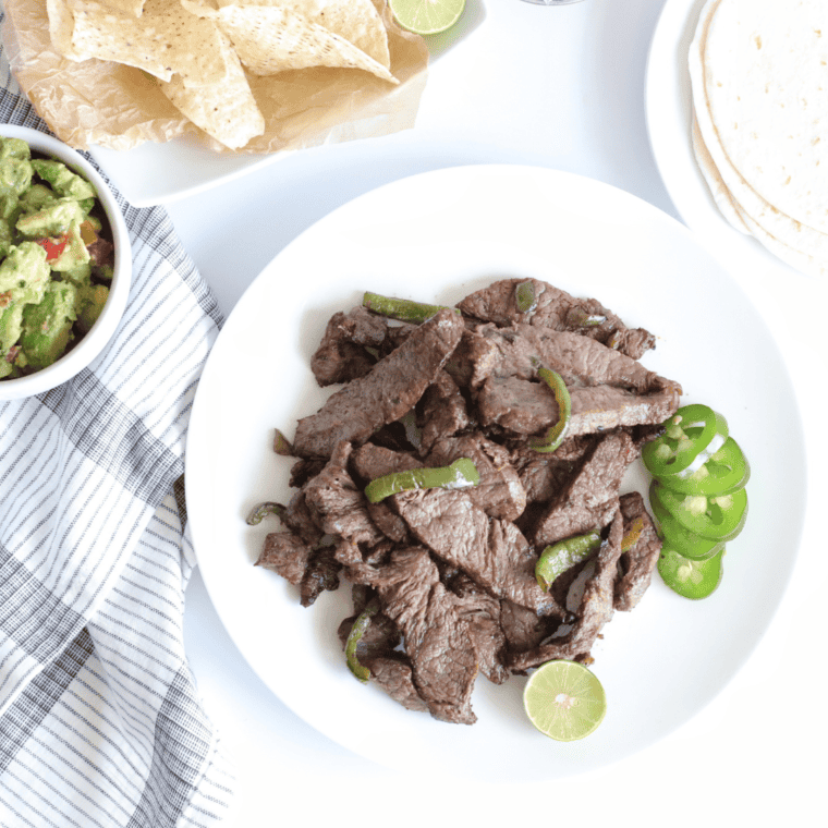 Air Fryer Steak Fajitas with charred peppers and onions piled on a warm flour tortilla