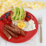 Plate of Ninja Crispi breakfast sausage links served with two fried eggs and fresh fruit