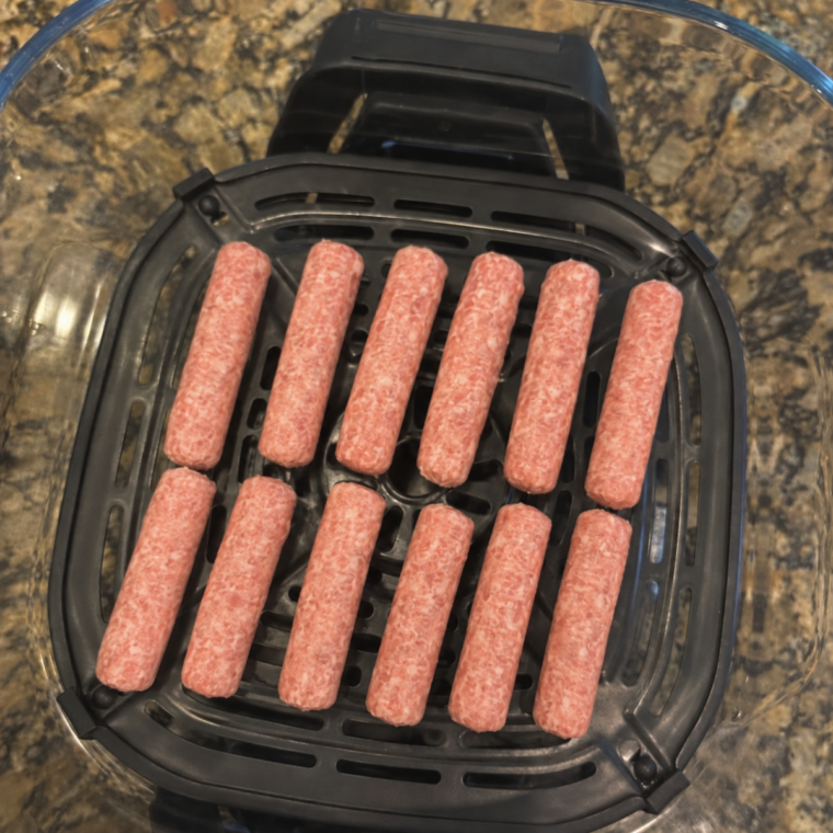 Raw breakfast sausage links arranged in a single layer on the Ninja Crispi crisper plate
