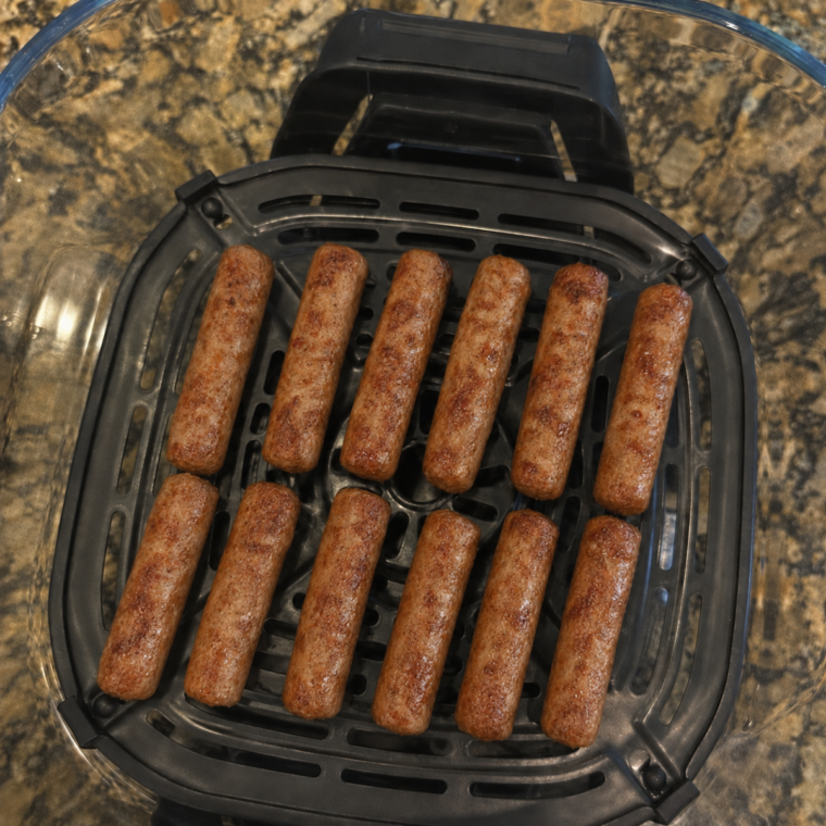 Cooked breakfast sausage links in the Ninja Crispi glass container on the crisper plate