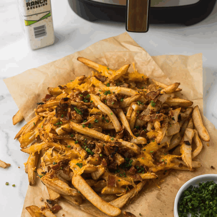 Texas Roadhouse-style cheese fries topped with melted cheddar, bacon bits, and green onions on a plate.