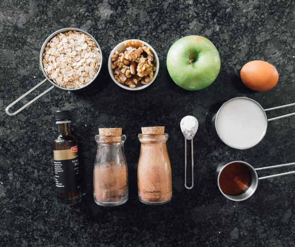 Ingredients Needed For Air Fryer Apple Pie Baked Oatmeal on table with fresh apples, bottles and measurements