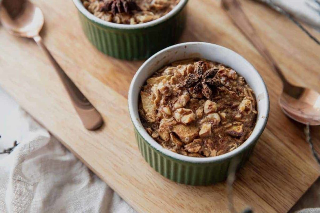Cooked Apple Oatmeal place on a wooden cutting board, with spoons on the side.