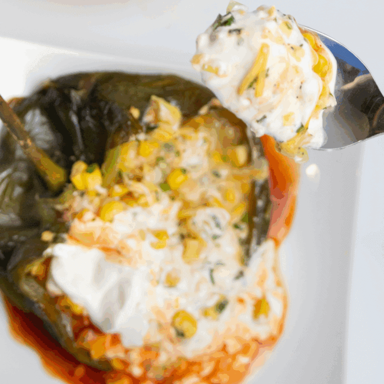 Cheese-stuffed chile rellenos cooked in the air fryer, golden and crispy with melted cheese oozing out.