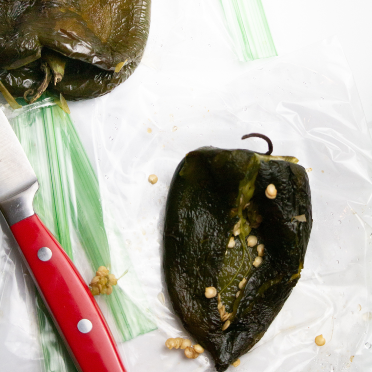 Poblano peppers roasting in an air fryer basket at 400°F, starting to blister and char.