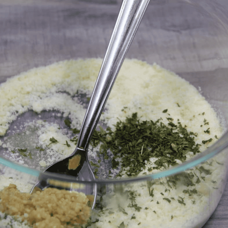 You are mixing grated Parmesan cheese with garlic powder and other ingredients to create a creamy sauce.