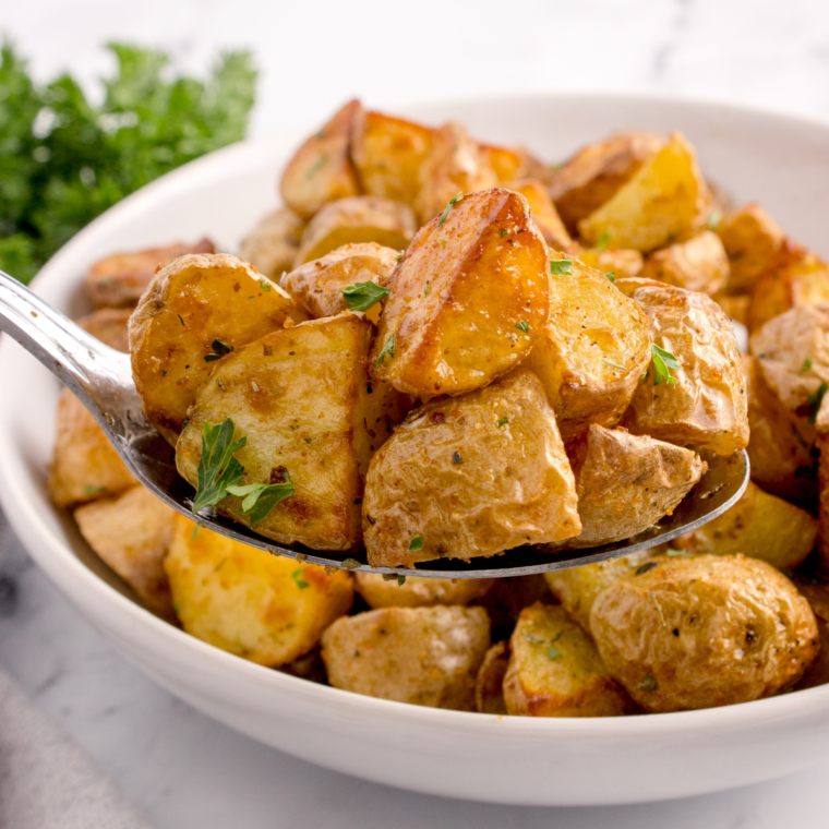 Air fryer rosemary roasted potatoes garnished with extra fresh rosemary