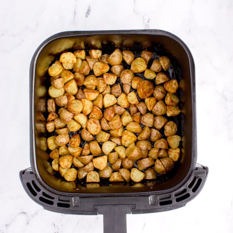 Rosemary potatoes halfway through cooking, edges starting to brown