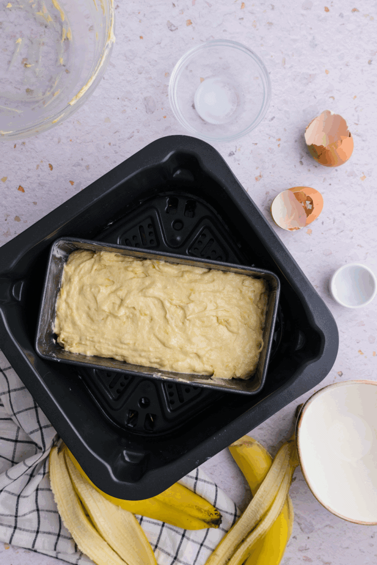 Banana cake batter poured into greased pan, placed in air fryer, set to 320°F for 25–30 minutes.