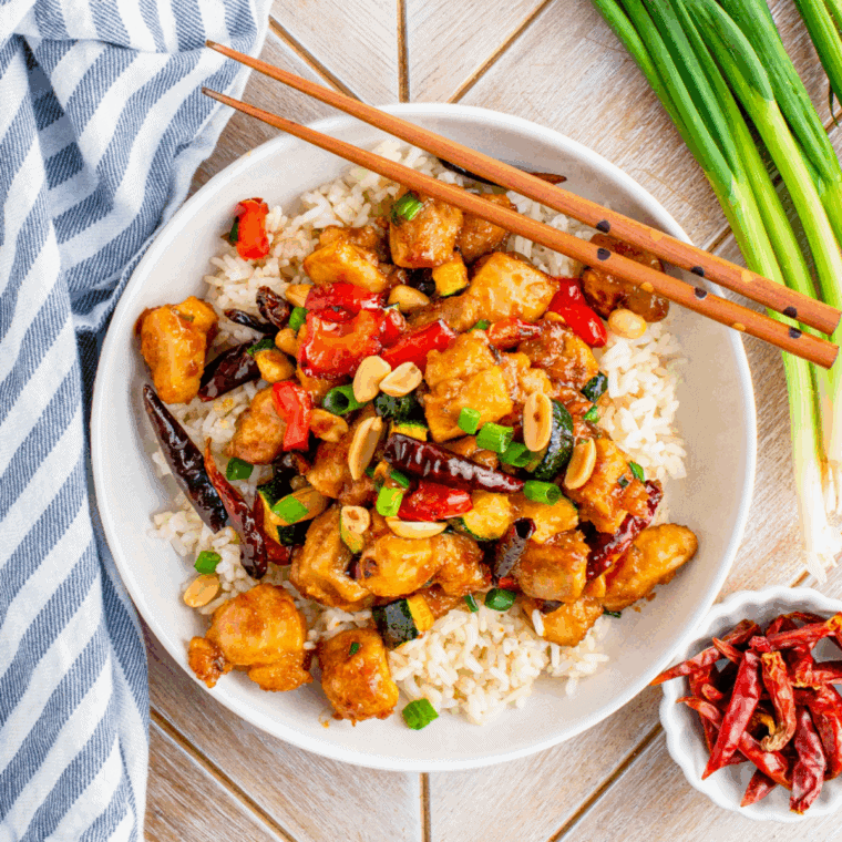 Plate of crispy air fryer Kung Pao chicken with peanuts and bell peppers.