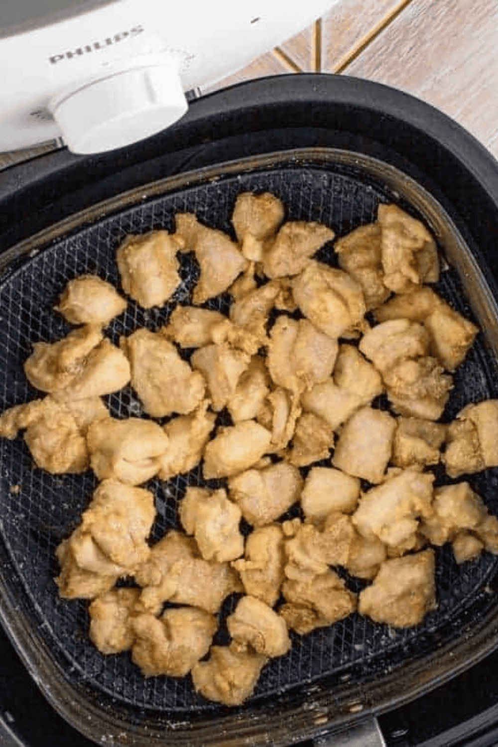 Cooked chicken in the air fryer basket.
