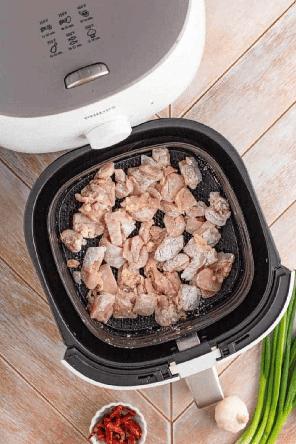 Place raw chicken bites into the air fryer basket.