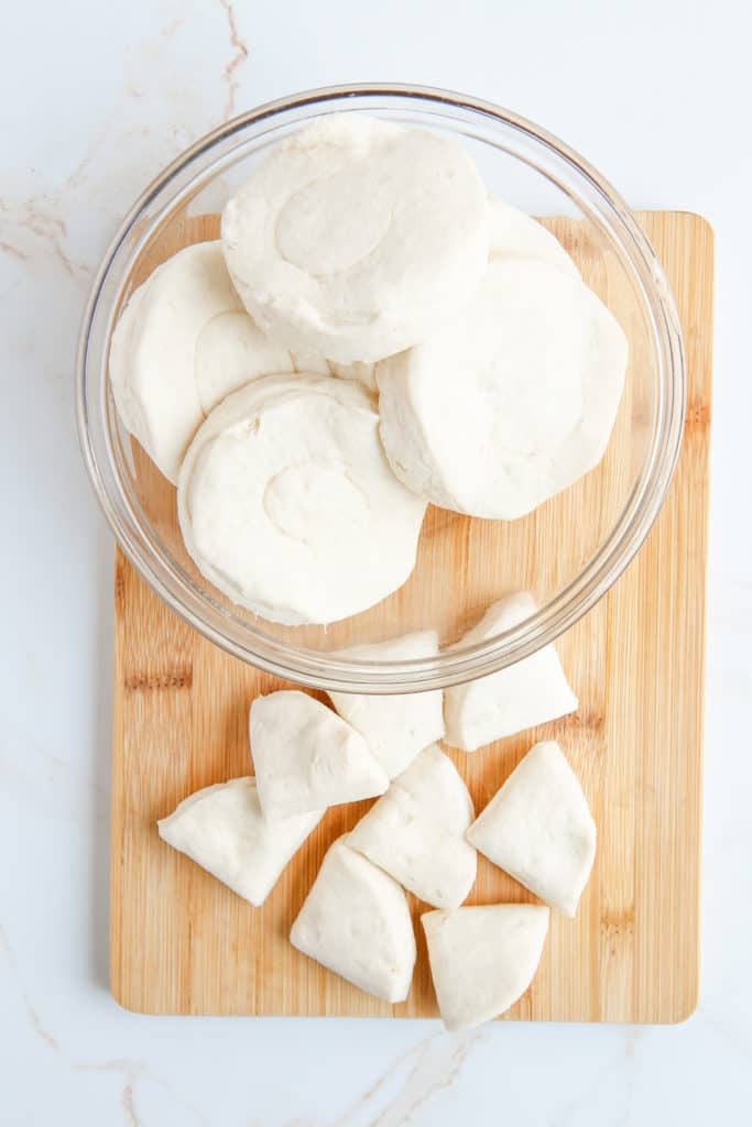 Start by cutting your biscuit dough into 4 pieces.