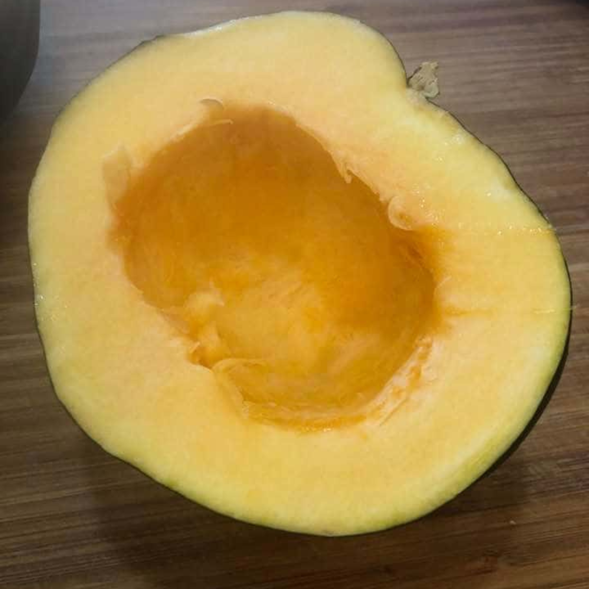 Seasoning acorn squash slices with olive oil and spices before air frying.