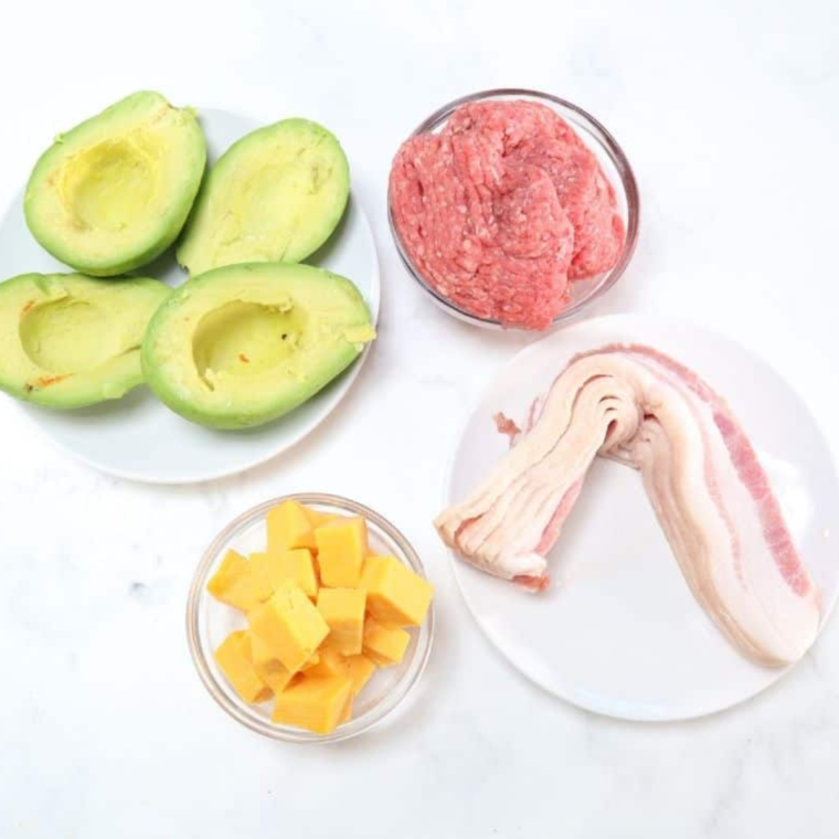 Ingredients needed for Air Fryer Bacon-Wrapped Avocado Burger Bombs on kitchen table.