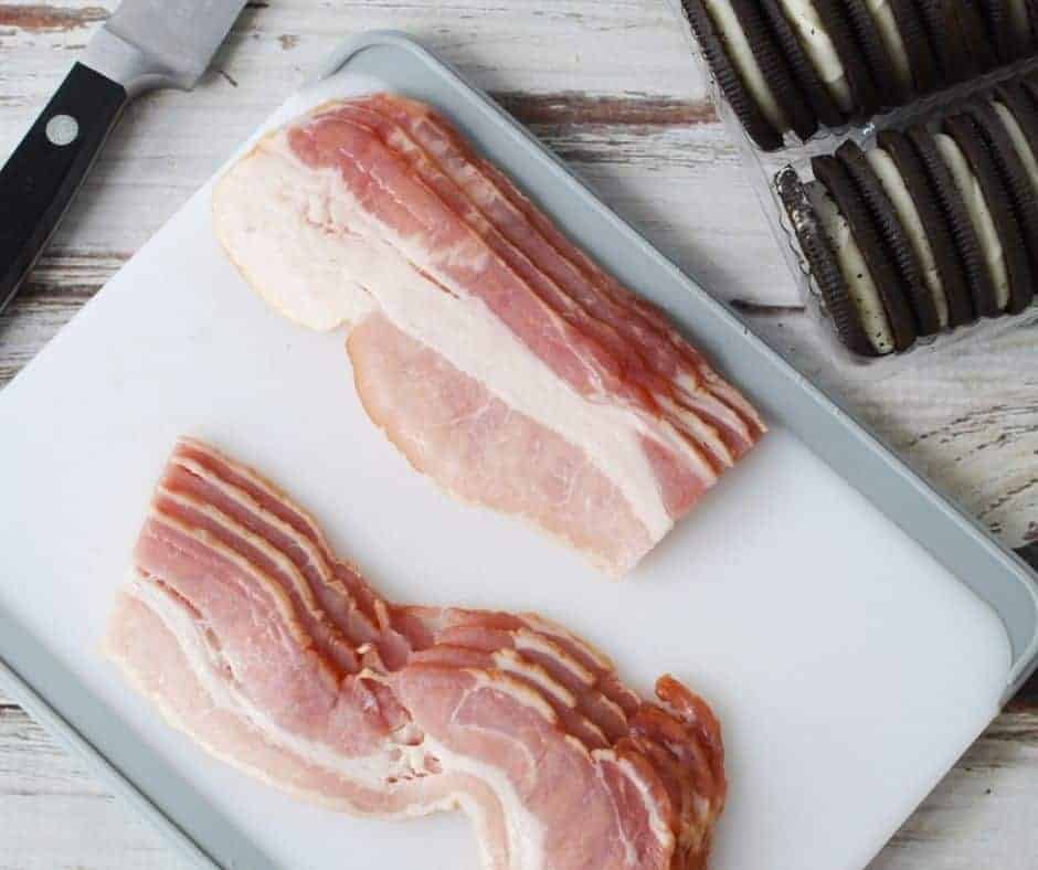 Ingredients for Air Fryer Bacon Wrapped Oreos, including Oreos, bacon, and cooking spray laid out on a kitchen counter.