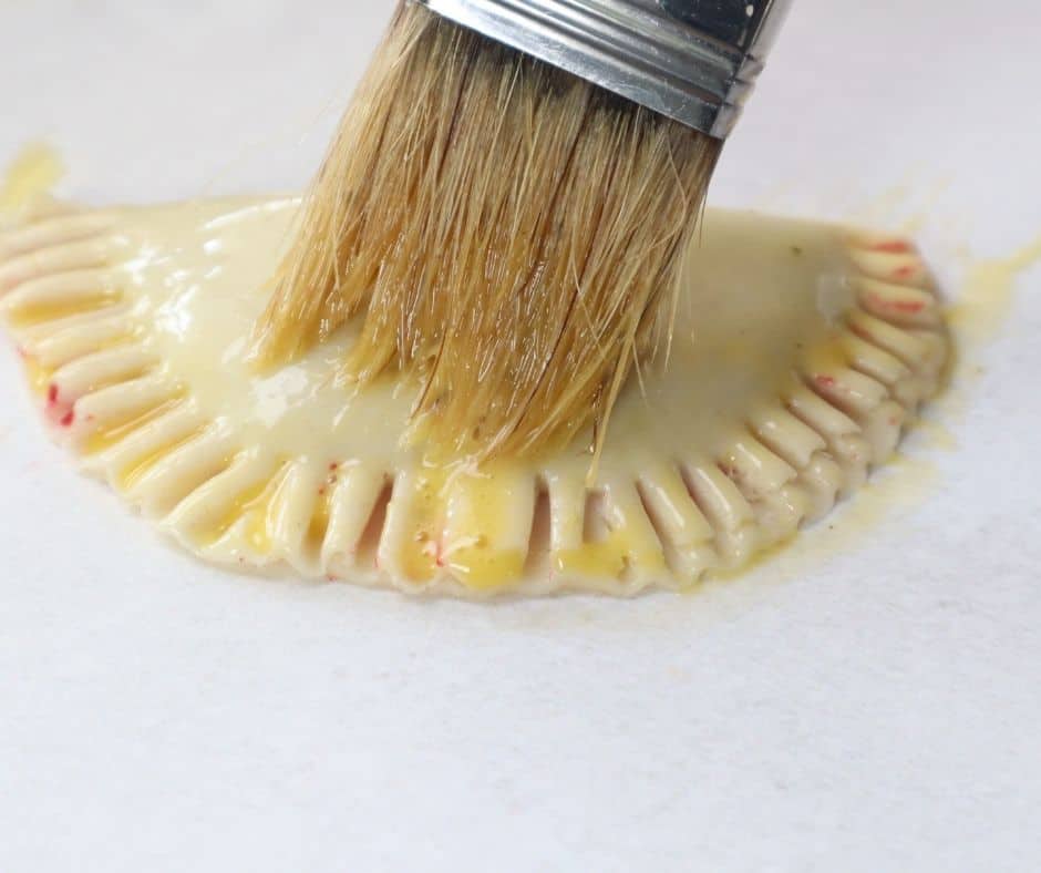 "Crimping edges of hand pies with a fork to seal them"