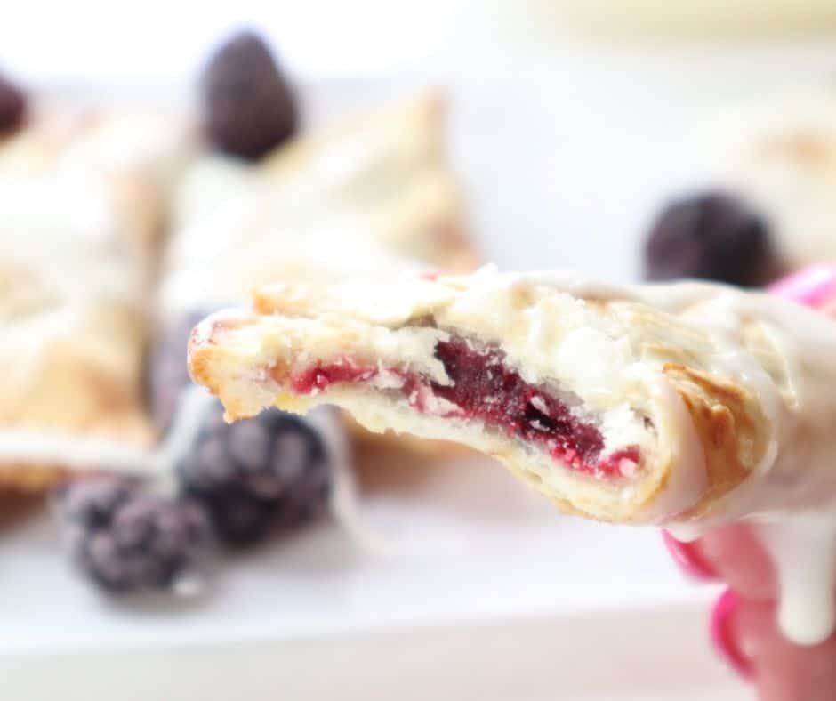 Drizzling powdered sugar glaze over the baked hand pies