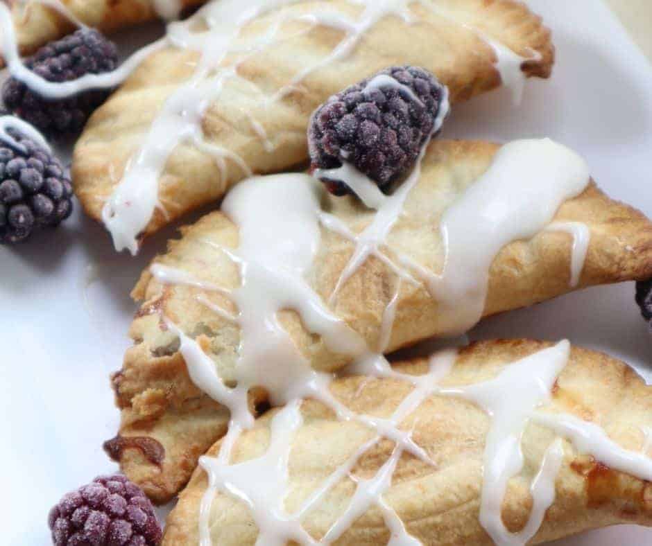 "A plate of Air Fryer Blackberry Hand Pies with golden, flaky crusts and juicy blackberry filling"